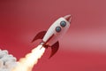 Cartoon Rocket Launching with Fiery Exhaust and Smoke Against Red Background Royalty Free Stock Photo