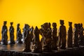 Stylized chess pieces on a board with orange background and selective focus