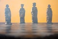 Stylized chess pieces on a board with orange background, smoke and selective focus