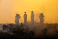 Stylized chess pieces on a board with orange background, smoke and selective focus