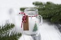 Stylized Christmas candle in a small jar with an inscription tag.