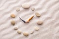 Stylized dial clock pebble and shells arrows on the sand for concentration and relaxation for harmony and balance Royalty Free Stock Photo