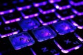 Gaming laptop keyboard with vivid purple-blue backlight. Neon glow stylization Royalty Free Stock Photo