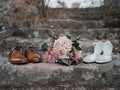 Stylized image of a pair of wedding shoes against a backdrop of rocks and a wedding bouquet