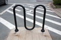 M-shaped black metal bike rack in parking lot