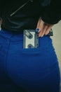 Stylized photo with a grain of woman holding audio cassette in a pocket