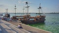 Stylized pirate ships moored to the shore on the waterfront.