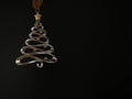 Stylized Silver-Toned Metal Christmas Tree Against Black Background