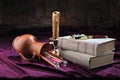 Stylized view of retro objects. On the table are: old books, a candlestick, a candle, colored pencils in an overturned jug and a m