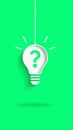 stylized white light bulb with a green question mark inside hangs against a vivid green background Royalty Free Stock Photo