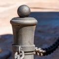 Stylus of street fencing made of metal with chain, Tarragona, Spain. Close-up. Royalty Free Stock Photo