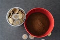 Styrofoam cup full of coins with red bowl of instant coffee