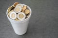 Styrofoam cup full of coins saved for a rainy day