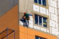 Styrofoam insulation of high-rise building. Rope access working. Concept of industrial alpinism