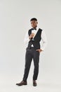 Suave man in tuxedo gracefully holds Royalty Free Stock Photo