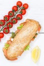 Sub sandwich whole grain grains baguette with salmon fish portrait format from above on wooden board