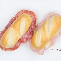 Sub sandwiches baguettes with salami ham and cheese square from above on wooden board Royalty Free Stock Photo