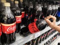 Subang Jaya,Malaysia - 18 June 2021 : Hand pick up a new Coca Cola bottles drink flavour display for sell on the supermarket.