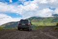 Subaru Forester car stand on a dirt road in the green mountains