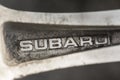 Subaru - the logo of the automobile company, engraved on the spoke of the original aluminum alloy wheels close-up. old