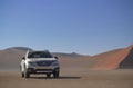 Subaru Outback stands in the middle of the Namib Desert, next to a sand dune of Sossusvlei. Royalty Free Stock Photo