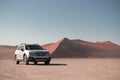 Subaru Outback stands in the middle of the Namib Desert, next to a sand dune of Sossusvlei. Royalty Free Stock Photo