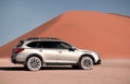 Subaru Outback stands in the middle of the Namib Desert, next to a sand dune of Sossusvlei. Royalty Free Stock Photo