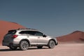 Subaru Outback stands in the middle of the Namib Desert, next to a sand dune of Sossusvlei. Royalty Free Stock Photo