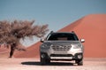 Subaru Outback stands in the middle of the Namib Desert, next to a sand dune of Sossusvlei. Royalty Free Stock Photo