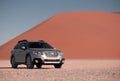 Subaru Outback stands in the middle of the Namib Desert, next to a sand dune of Sossusvlei. Royalty Free Stock Photo