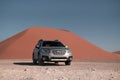 Subaru Outback stands in the middle of the Namib Desert, next to a sand dune of Sossusvlei. Royalty Free Stock Photo