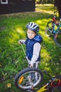 Subject child and profession. A little blond Caucasian boy uses a bicycle pump, pumps air into a tire wheel bicycle, a child Royalty Free Stock Photo