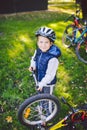 Subject child and profession. A little blond Caucasian boy uses a bicycle pump, pumps air into a tire wheel bicycle, a child Royalty Free Stock Photo