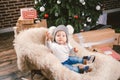 Subject children christmas new year. Caucasian little funny baby boy 1 year old sitting sleigh bear skin Christmas tree head warm Royalty Free Stock Photo