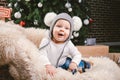 Subject children christmas new year. Caucasian little funny baby boy 1 year old sitting sleigh bear skin Christmas tree head warm