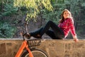 Subject ecological bicycle transport. A young caucasian woman in jeans and a shirt student sits resting in a park near the lake Royalty Free Stock Photo