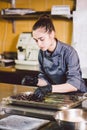 Subject profession and cooking pastry. young Caucasian woman with tattoo of pastry chef in kitchen of restaurant preparing round Royalty Free Stock Photo