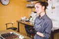 Subject profession and cooking pastry. young Caucasian woman with tattoo of pastry chef in kitchen of restaurant preparing round Royalty Free Stock Photo