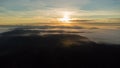 Sublime scenery of beautiful sunrise above clouds over misty mountains