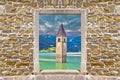 Submerged bell Tower of Curon Venosta or Graun im Vinschgau on Lake Reschen landscape view through stone wall gate