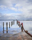 Submerged lagoon pier under a cloudy sky