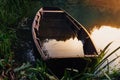 Submerged old wooden boat in sunset golden light, lake water surrounded Royalty Free Stock Photo