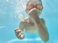 Submerged in summer. Shot of an adorable little boy wearing goggles while swimming underwater. Royalty Free Stock Photo