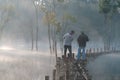 Submerged trees reflecting on lake with the magic light, fog and people active at sunrise part 7 Royalty Free Stock Photo