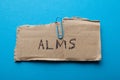 Submit alms, concept. Old torn cardboard on a blue background Royalty Free Stock Photo