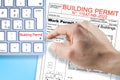 SUBMITTING FOR A BUILDING PERMIT CONCEPT with fictional Building Permit and text written over computer keyboard