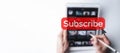 Subscribe banner. Online video subscription red button. Internet service on laptop digital tablet blured technology