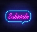 Subscribe neon text in a speech bubble frame on a brick wall background.