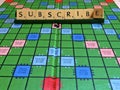 Subscribe word written on scrabble for content creation Royalty Free Stock Photo