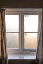 Substandard housing in England, UK, with condensation on window with curtains Royalty Free Stock Photo